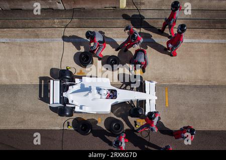 Boxencrew in perfekter Synchronisierung während eines Boxenstopps am Tag eines Highspeed-Rennens. Stockfoto