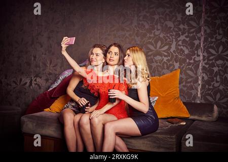 Freunde von selfie auf Sofa bei Nachtclub Stockfoto
