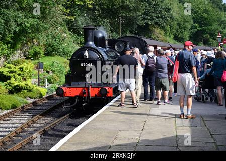 Die Passagiere sammeln sich um die L&Y-Klasse 25 0-6-0 2F-Lokomotive Nr. 52044 am Bahnhof Oxenhope der Keighley & Worth Valley Railway. Stockfoto