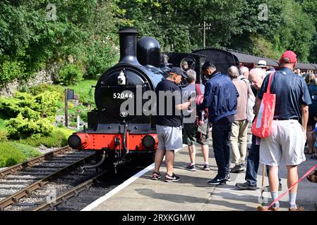 Die Passagiere sammeln sich um die L&Y-Klasse 25 0-6-0 2F-Lokomotive Nr. 52044 am Bahnhof Oxenhope der Keighley & Worth Valley Railway. Stockfoto