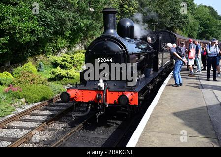 Die Passagiere sammeln sich um die L&Y-Klasse 25 0-6-0 2F-Lokomotive Nr. 52044 am Bahnhof Oxenhope der Keighley & Worth Valley Railway. Stockfoto