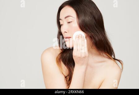 Junge Frau mit wattepad Abwischen Stockfoto