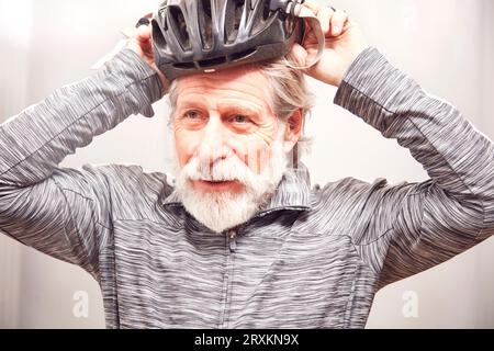 Ältere Menschen setzen auf Fahrrad Helm Stockfoto