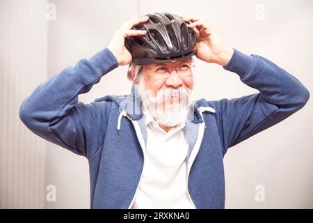 Ältere Menschen setzen auf Fahrrad Helm Stockfoto