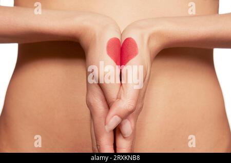 Body Paint Herz auf gefalteten Händen gezogen Stockfoto