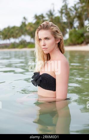 Junge Frau mit schwarzen Bikini im Meer stehend Stockfoto