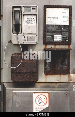 Im Inneren einer alten Telefonkabine, silberfarbene Telefonkabine, vertikale Aufnahme Stockfoto