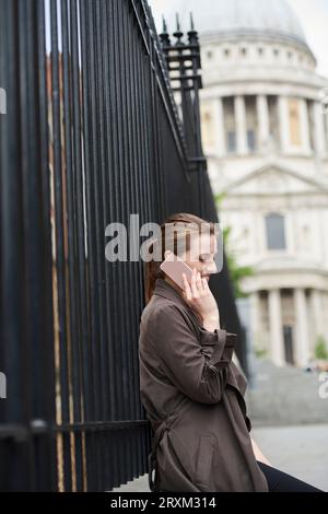 Mitte der erwachsenen Frau am Telefon Stockfoto