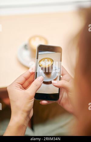 Hände von Frau Kaffee fotografieren mit smart phone Stockfoto