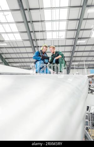 Männer, die ein digitales Tablet im Flugzeug im Hangar benutzen Stockfoto