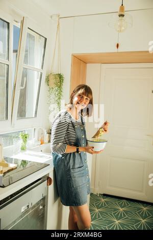 Frau mit Zucchini-Nudeln in der Küche Stockfoto