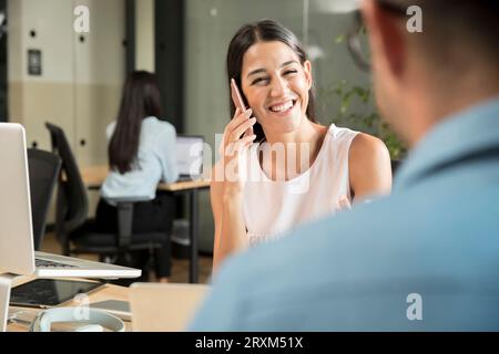 Lächelnde junge Frau mit smart phone Stockfoto