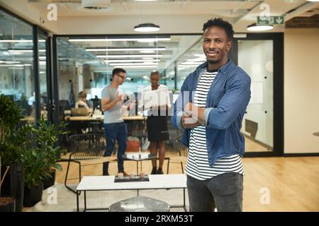 Lächelnde junge Geschäftsmann im Büro Stockfoto