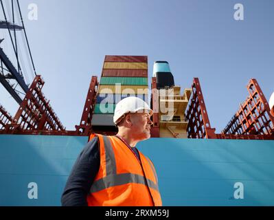Hafenarbeiter durch Frachter im Hafen von Felixstowe, England Stockfoto