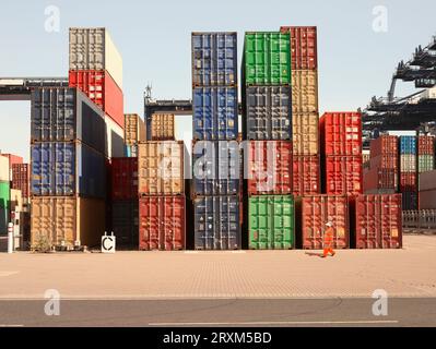 Hafenarbeiter durch Stapel von Frachtcontainern Stockfoto