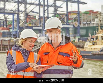 Hafenarbeiter mit digitalen Tablet am Hafen von Felixstowe, England Stockfoto