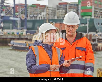 Hafenarbeiter mit digitalen Tablet am Hafen von Felixstowe, England Stockfoto