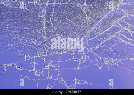 Glas zerbrochen in eine große Anzahl von Stücken und Rissen, ein Stück Glas mit einer großen Anzahl von Rissen und gebrochenen Teilen Stockfoto