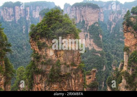 Entdecken Sie die Ruhe, während grünes Gras die majestätischen langen Berge unter Chinas atemberaubendem blauen Himmel bedeckt. Stockfoto