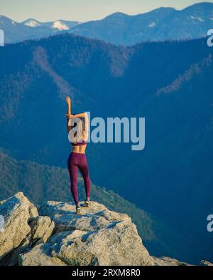 Junge Frau stretching auf Felsen Stockfoto