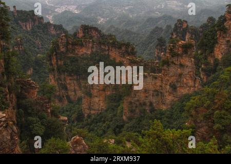 Entdecken Sie die Ruhe, während grünes Gras die majestätischen langen Berge unter Chinas atemberaubendem blauen Himmel bedeckt. Stockfoto