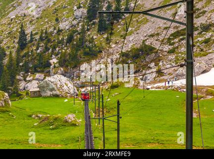 Toller Blick auf die bergige Landschaft mit der roten Zahnradbahn der Welt, die von der Bergstation Pilatus Kulm abfährt... Stockfoto