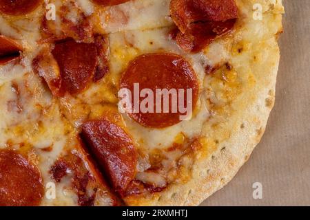 Kleine hausgemachte, würzige Pizza mit Wurst und Käse, gekühlte, kleine Pizza mit würzigen Gewürzen Stockfoto