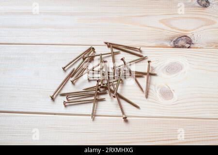 Ein Stapel Schrauben auf einem Holztisch. Blechschraube für Holz Stockfoto