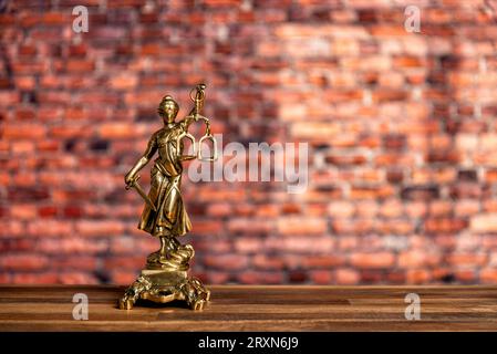 Statue von Lady Justice, Göttin Justitia, auf dem Schreibtisch in einem Anwaltsbüro auf Büchern Stockfoto