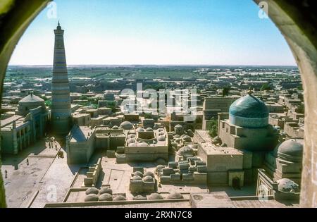 Archivbild aus den 1980er Jahren von einem Minarett der Dzhuma-Moschee in die Altstadt von Chiwa, Usbekistan. Zeigt einen halbhohen Blick über die Altstadt zum Wachtturm-Minarett und dem Mausoleum von Pahlavan Mahmud. Stockfoto