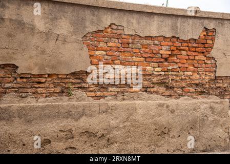 Cemento scrostato su vecchio muro con mattoni a vista Stockfoto
