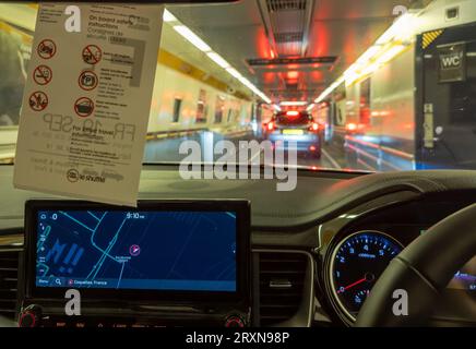 Ein Auto fährt nachts in Coquelles bei Calais in Frankreich in den Eurotunnel, bevor es unter dem Ärmelkanal nach Folkes transportiert wird Stockfoto