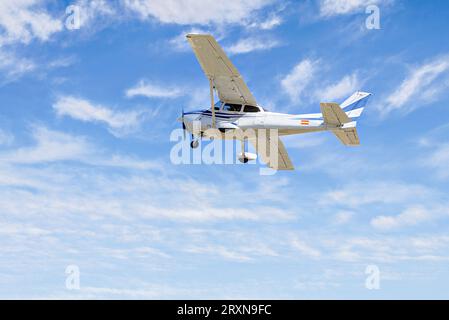 Ultraleichtes Einmotorflugzeug, das am blauen Himmel mit weißen Wolken fliegt Stockfoto