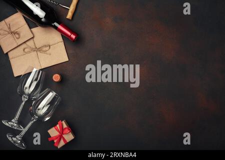 Flasche Wein, zwei Gläser, Geschenkbox, Umschlag, Korkenzieher und Korken, in der Draufsicht mit rostigem Hintergrund kopierst du Platz Stockfoto