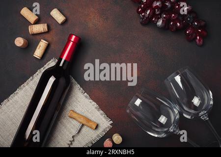 Flasche Wein, zwei Gläser, rote Trauben, Tuch, Korkenzieher und Korken, in der Draufsicht mit rostigem Hintergrund kopierst du Platz Stockfoto