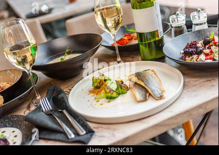 Dorado oder Wolfsbarschfilet in Sahnesauce mit Brokkoli auf weißem Teller. Hochwertige Fotos Stockfoto