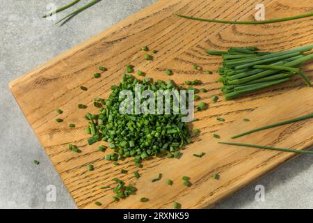 Bio-rohe, grüne, gehackte Chives auf einem Schneidebrett Stockfoto