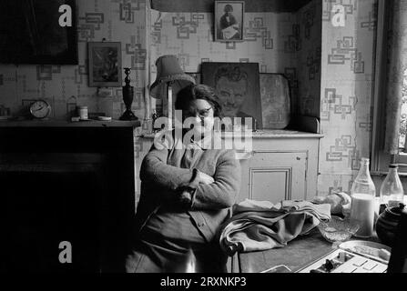 Ältere Dame saß im vorderen Raum ihres viktorianischen Hauses, das auf den Abriss während der Räumung des Slums von St Ann's, Nottingham, England, wartet. Stockfoto