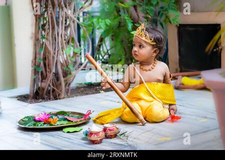 Entzückendes Kleinkind gekleidet als hindugott krishna niedlicher Gesichtsausdruck mit Flöte bei Janmashtami Stockfoto