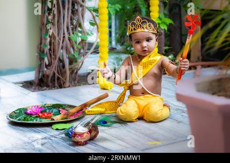 Entzückendes Kleinkind gekleidet als hindugott krishna niedlicher Gesichtsausdruck mit Flöte bei Janmashtami Stockfoto