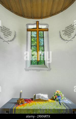 Altar mit Buch, Kerze und Blumendekoration, Spitalkirche, Bad Groenenbach, Allgaeu, Bayern, Deutschland Stockfoto