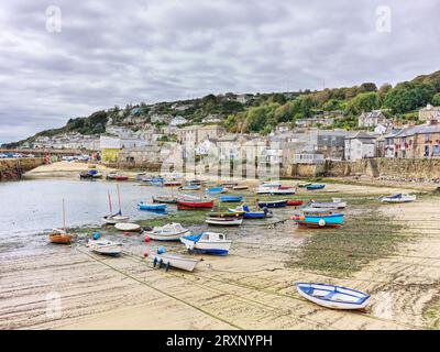Boote legten im Hafen von Mousehole, Cornwall, England, an, mit der Flut. Stockfoto