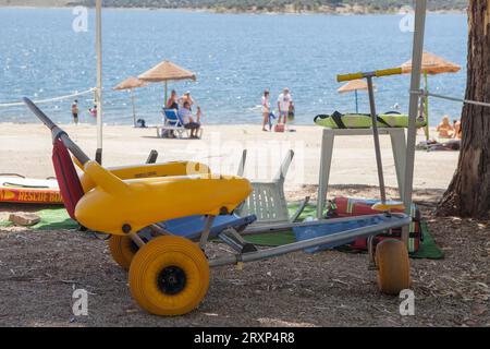 Rollstuhl am Strand in der Nähe des Stausees, gebrauchsfertig. Barrierefreies Tourismuskonzept Stockfoto