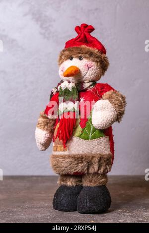 Schneemannfigur zur Dekoration in den Neujahrsferien auf grauem Hintergrund. Stockfoto