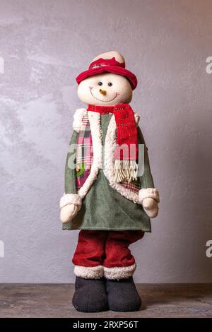 Schneemannfigur zur Dekoration in den Neujahrsferien auf grauem Hintergrund. Stockfoto