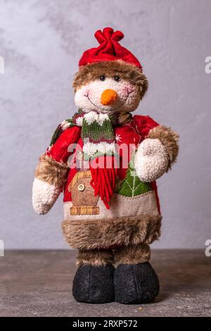 Schneemannfigur zur Dekoration in den Neujahrsferien auf grauem Hintergrund. Stockfoto