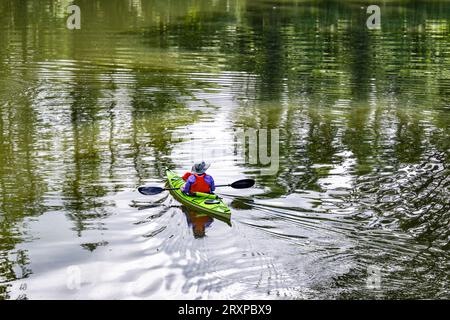 Gewöhnlicher smarter Mann bevorzugt Outdoor-Aktivitäten für einen gesunden Lebensstil, um die Gesundheit zu verbessern Ruhen auf Kajak auf dem Spiegelwasser eines Lacamas Lake fra paddeln Stockfoto