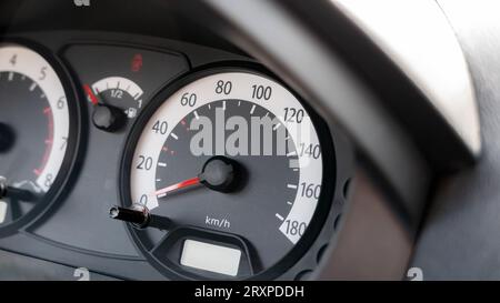 Tachometer in einem einfachen, generischen, bewegungslosen, gestoppten Fahrzeug, Objektdetails, die die Geschwindigkeit in Kilometern pro Stunde, km/h Einheit, 0 bis 180 Geschwindigkeit anzeigen Stockfoto
