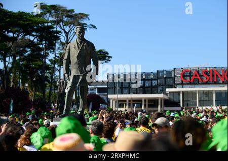 Erste Versammlung der WYD-Freiwilligen in Jardim do Estoril, Estoril, Porugal. Die Statue von Fausto Cardoso de Figueiredo ragt über der Menge auf. Stockfoto