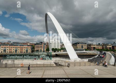 Newcastle upon Tyne, Vereinigtes Königreich - 30. August 2023: Ein einzelner Spaziergang vor dem Schild der Gateshead Millenium Bridge auf dem Weg zur Überquerung Stockfoto